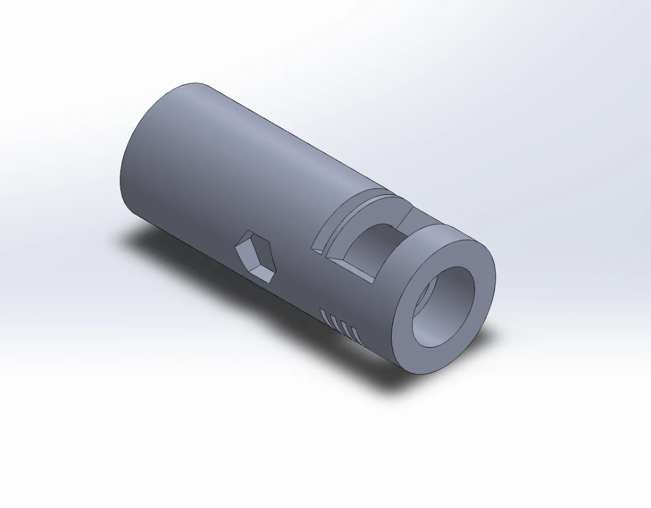 SolidWorks render of the grey cylindrical housing on its own, on a light background. One end has a bore. The side wall has a hexagonal pocket, a slot cut through the wall near the bored end, and a row of four small parallel grooves.